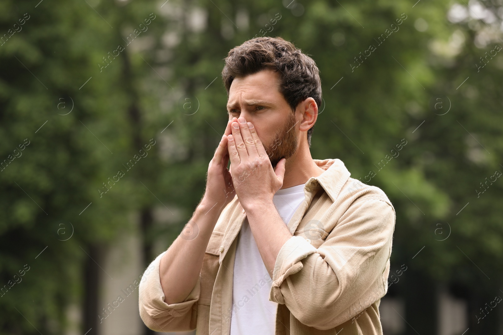 Photo of Man suffering from seasonal spring allergy outdoors