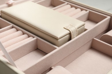 Photo of Empty beige jewelry box on table, closeup