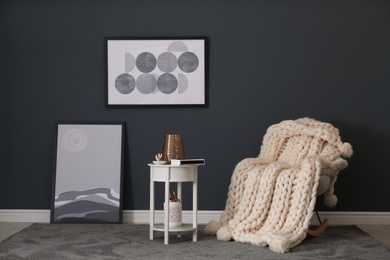 Photo of Rocking chair with white knitted plaid in room. Interior design