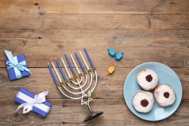 Flat lay composition with Hanukkah menorah and gift boxes on wooden table. Space for text
