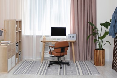 Photo of Stylish teenager's room interior with workplace and beautiful houseplant