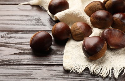 Sweet fresh edible chestnuts on wooden table, closeup