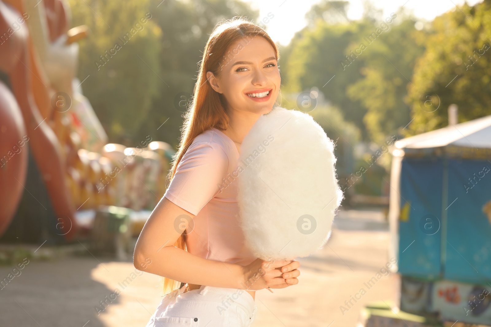 Photo of Portrait of happy woman with cotton candy outdoors on sunny day