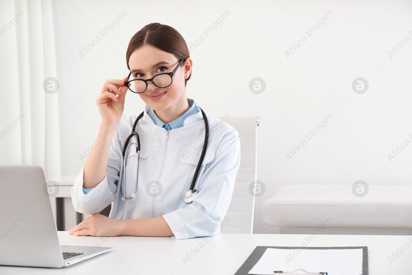 Photo of Portrait of young female doctor in white coat at workplace