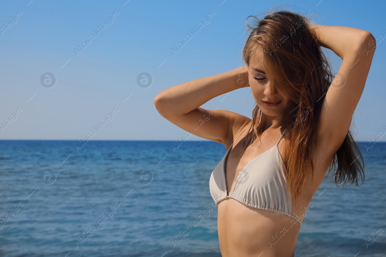 Photo of Attractive woman in bikini near sea on sunny day