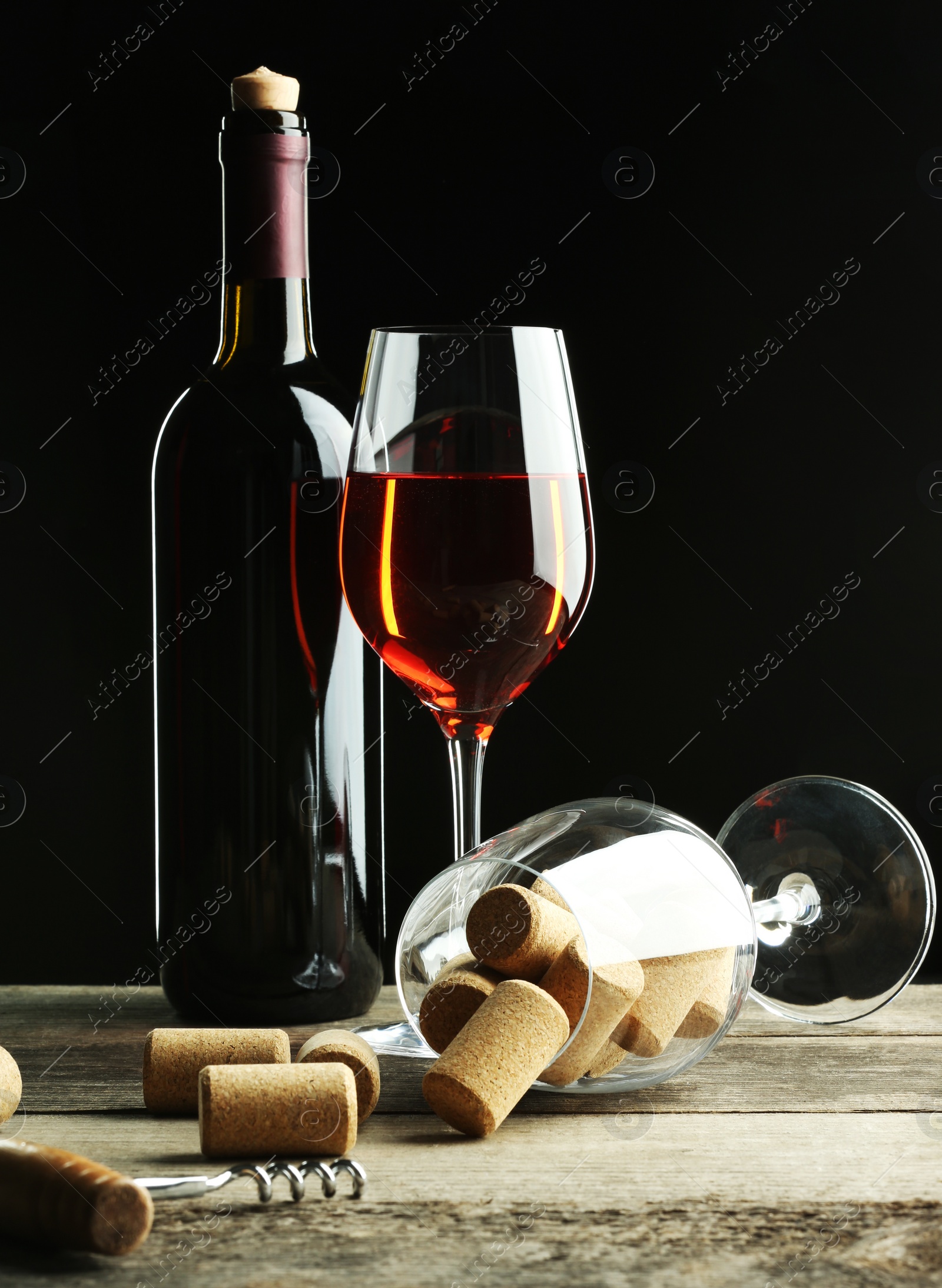 Photo of Red wine and corks on wooden table