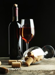 Red wine and corks on wooden table