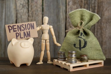 Photo of Card with phrase Pension Plan, stacks of coins, piggy bank, mannequin and sack on wooden table. Retirement concept