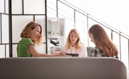 Young woman and her teenage daughter visiting child psychologist in office