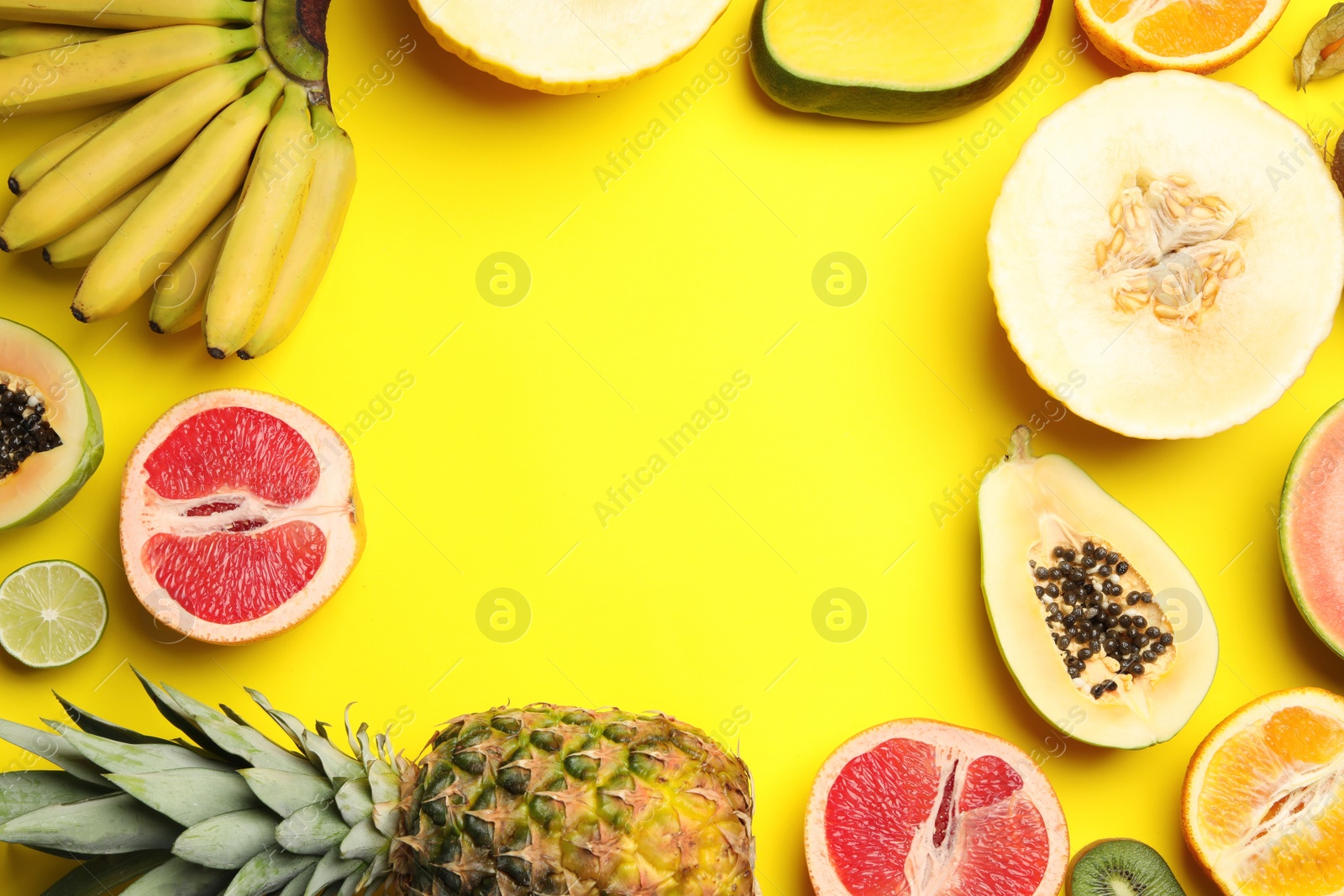 Photo of Frame made with tasty melon and fresh tropical fruits on yellow background, flat lay. Space for text