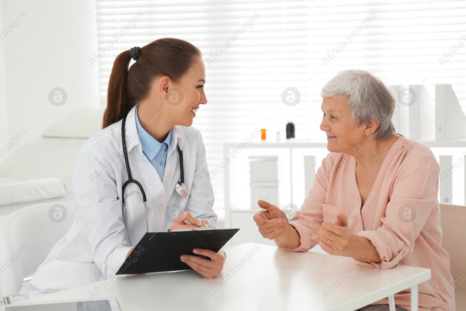 Photo of Doctor examining senior patient in modern office