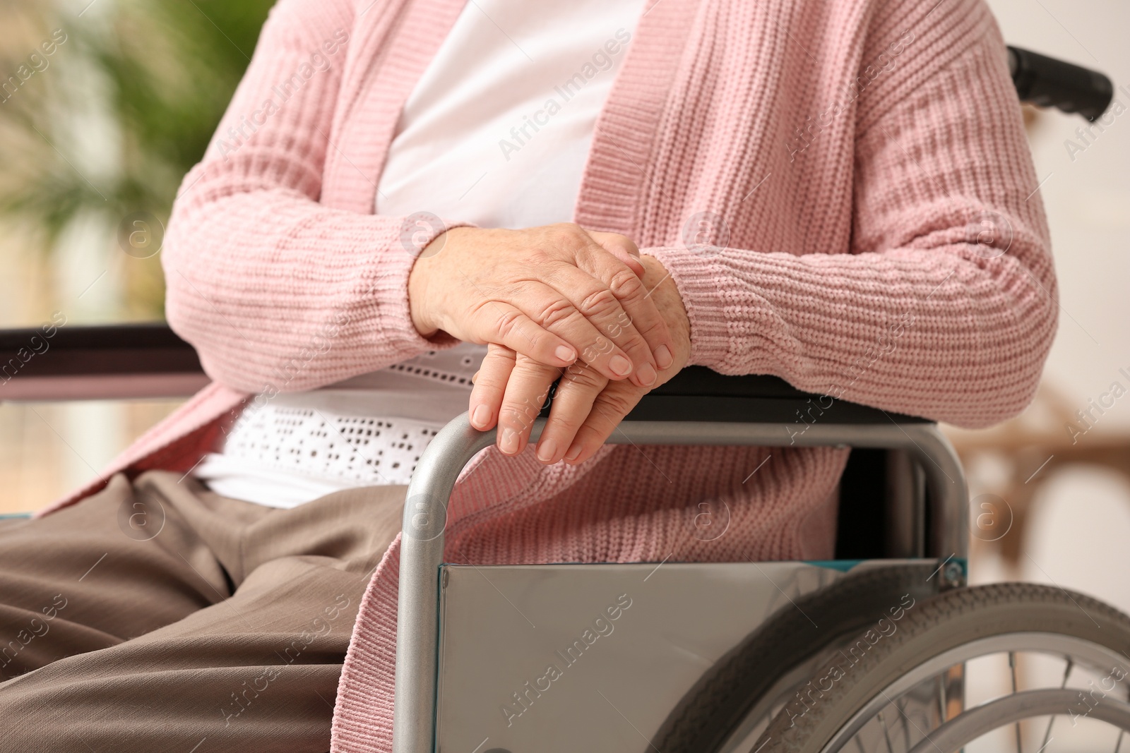 Photo of Handicapped elderly woman in nursing home, closeup. Assisting senior generation
