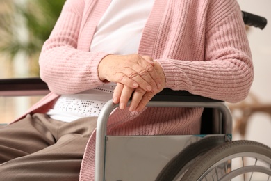 Handicapped elderly woman in nursing home, closeup. Assisting senior generation