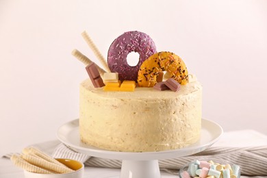 Photo of Delicious cake decorated with sweets on table against white background
