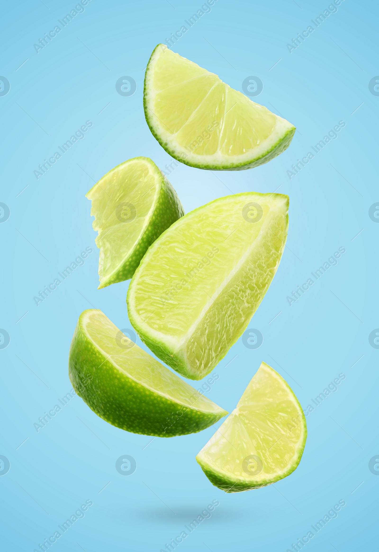 Image of Fresh lime slices falling on light blue background