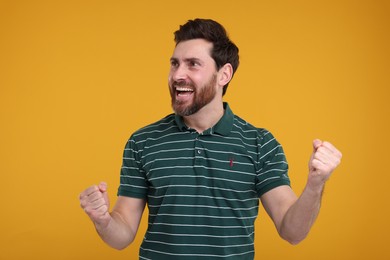Photo of Portrait of happy surprised man on yellow background