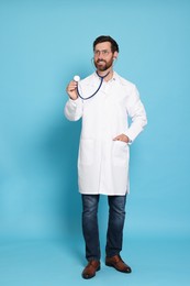Photo of Full length portrait of doctor with stethoscope on light blue background