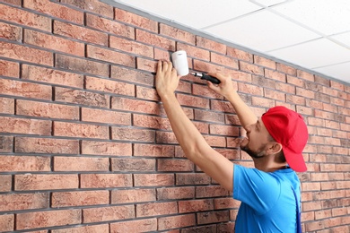 Male technician installing alarm system indoors