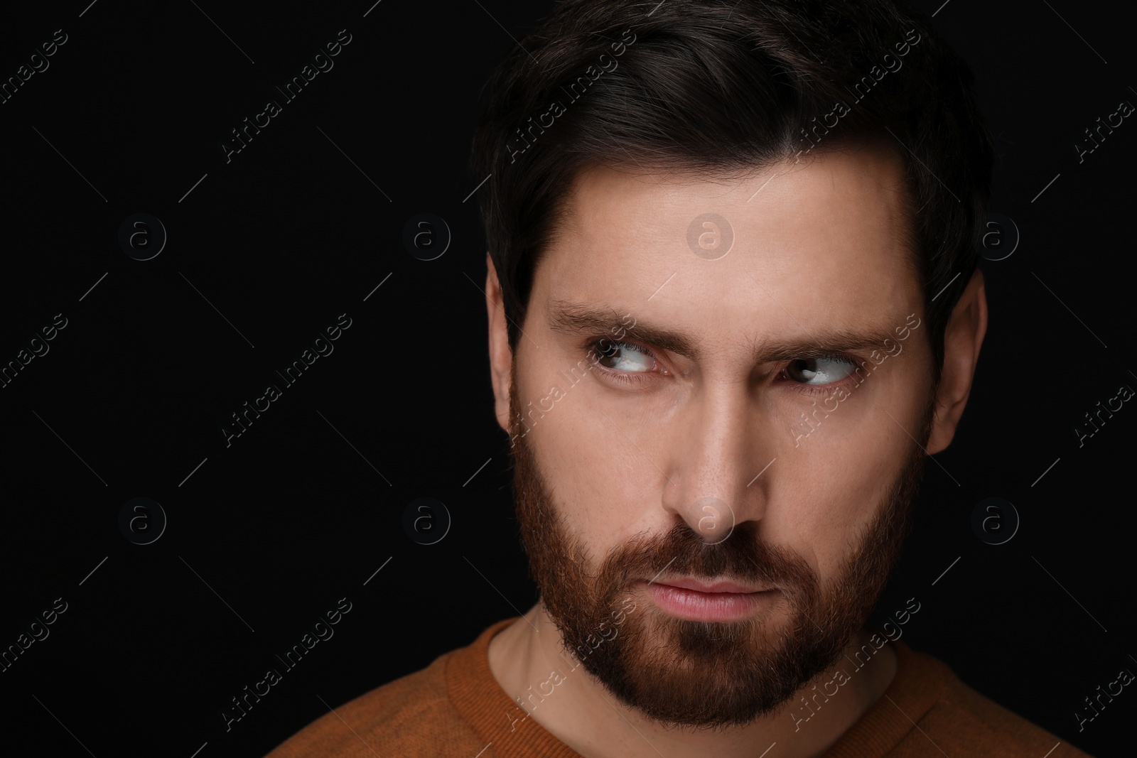 Photo of Evil eye. Man with scary eyes on black background, closeup and space for text