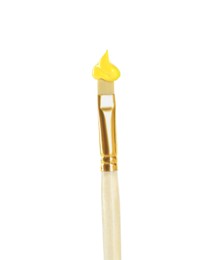 Photo of Brush with yellow paint on white background