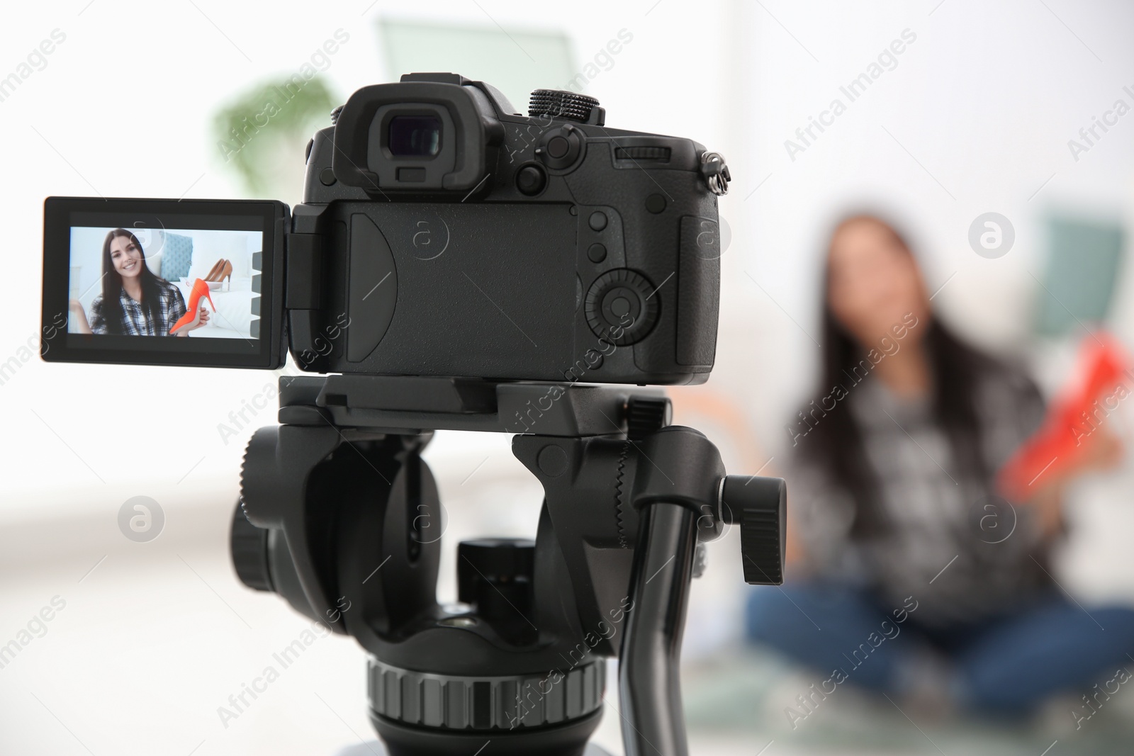 Photo of Young blogger recording video at cafe, focus on camera screen