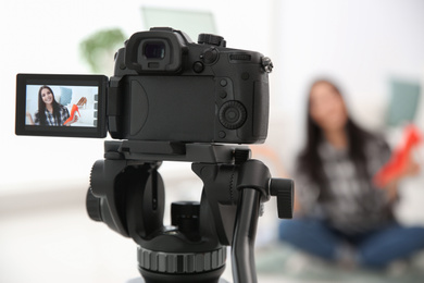 Photo of Young blogger recording video at cafe, focus on camera screen