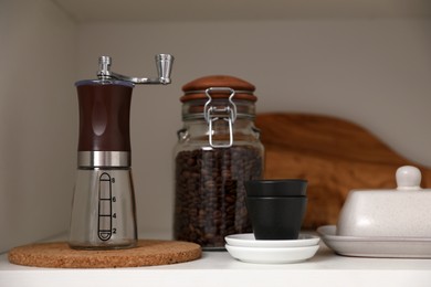 Photo of Manual coffee grinder on shelf in kitchen