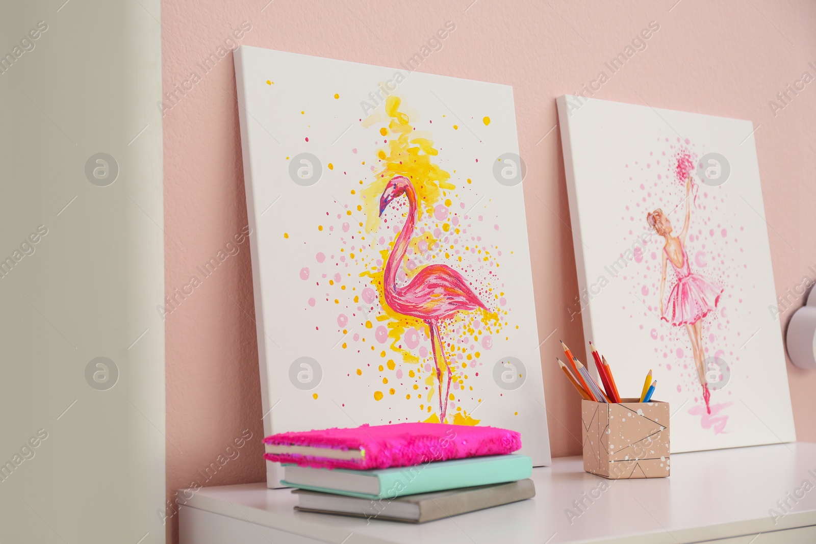 Photo of Stationery and pictures on white table in children's room. Interior design