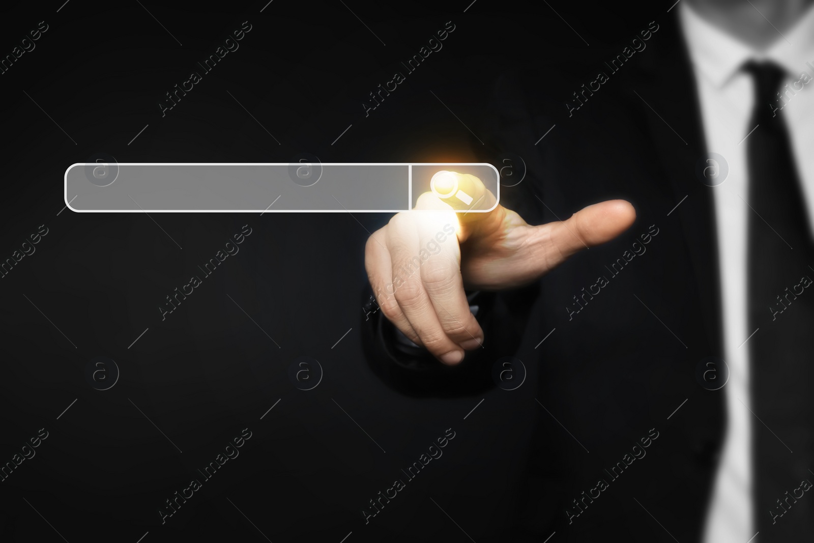 Image of Man pointing at search bar on virtual screen against black background, closeup