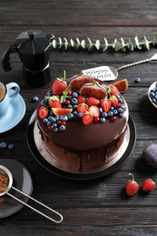 Fresh delicious homemade chocolate cake with berries on dark table