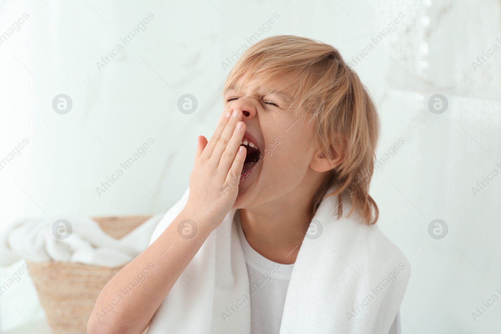 Photo of Cute little boy yawning in bathroom. Bedtime