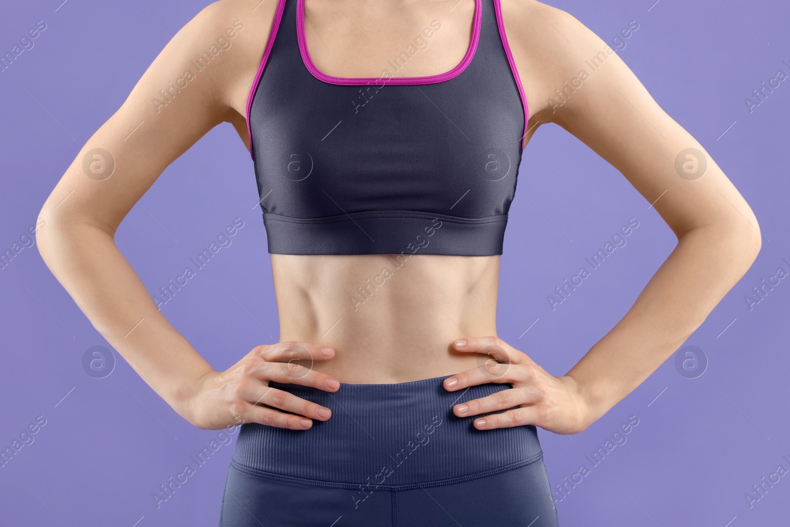 Photo of Woman wearing sportswear on violet background, closeup