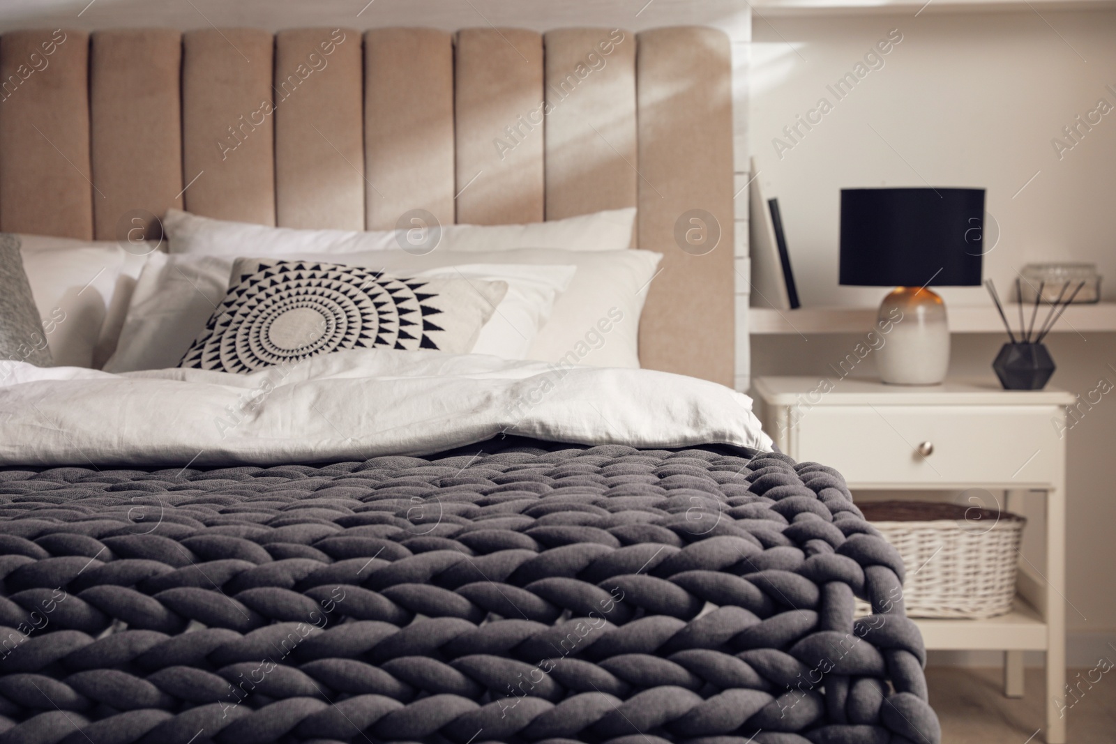 Photo of Soft chunky knit blanket on bed in stylish room interior