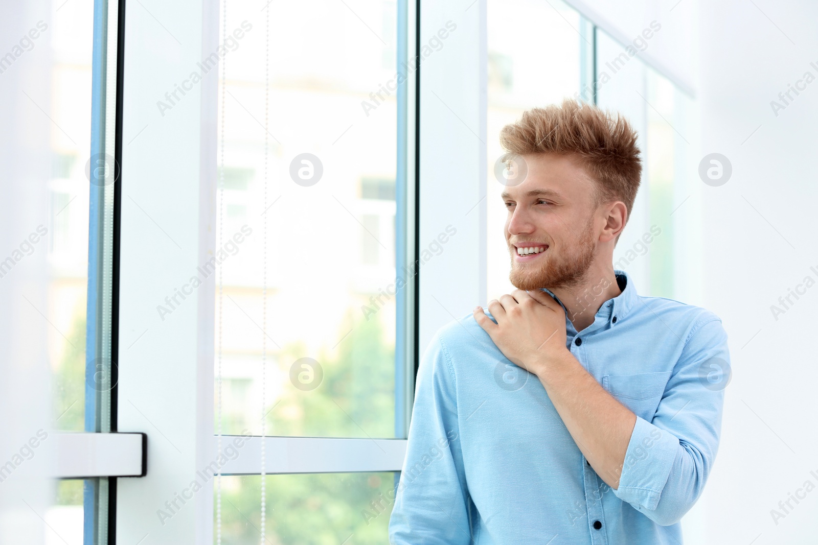 Photo of Portrait of handsome young man looking out window indoors