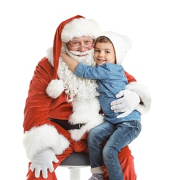 Little boy hugging authentic Santa Claus on white background