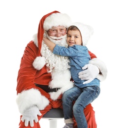 Photo of Little boy hugging authentic Santa Claus on white background