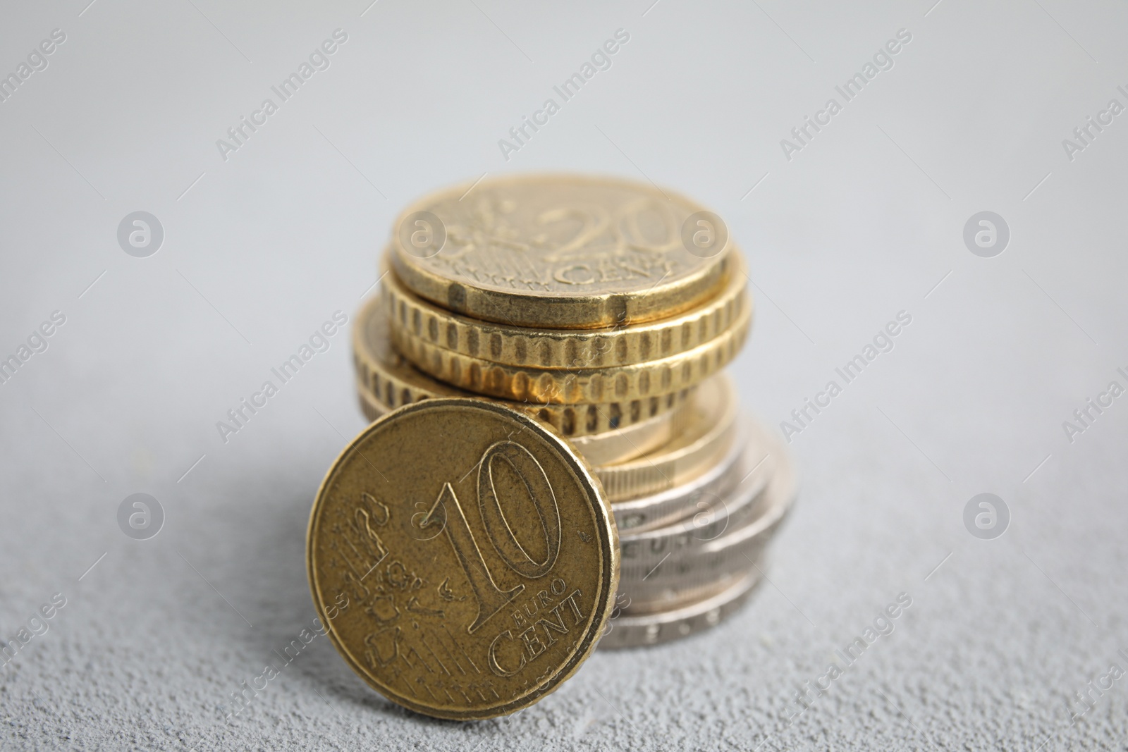 Photo of Many Euro coins on white table, closeup