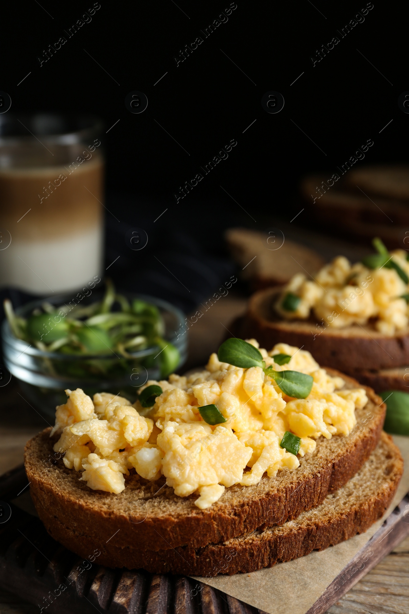 Photo of Tasty scrambled egg sandwich on wooden board