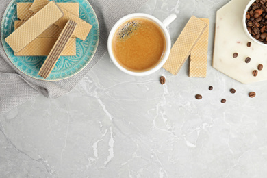 Breakfast with delicious wafers and coffee on grey marble table, flat lay. Space for text