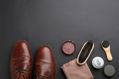 Flat lay composition with shoe care accessories and footwear on black background. Space for text