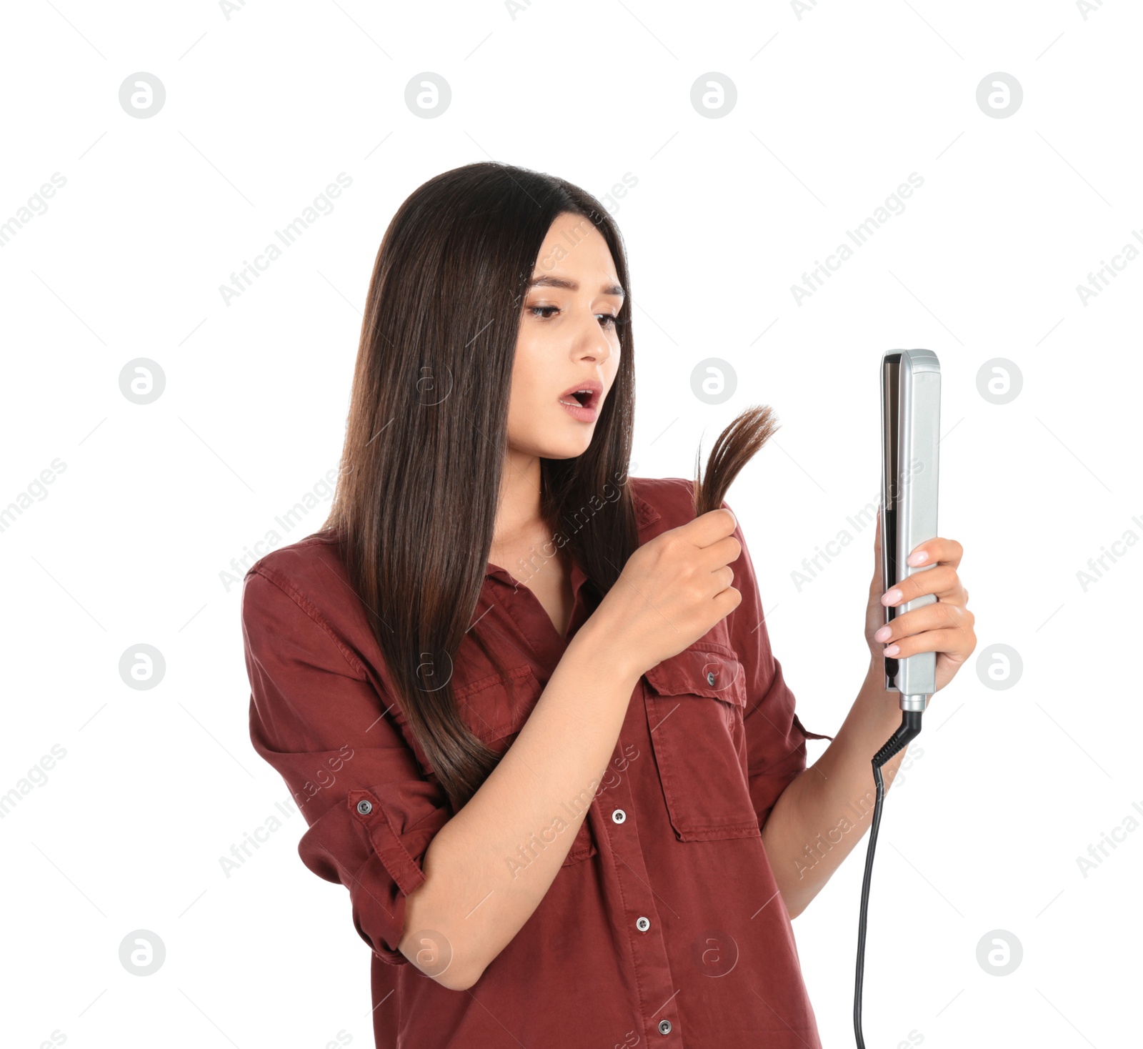 Photo of Upset woman with hair iron on white background