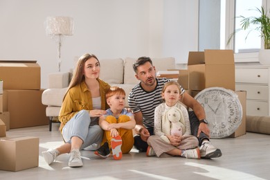 Photo of Family sitting on floor in new apartment. Moving day