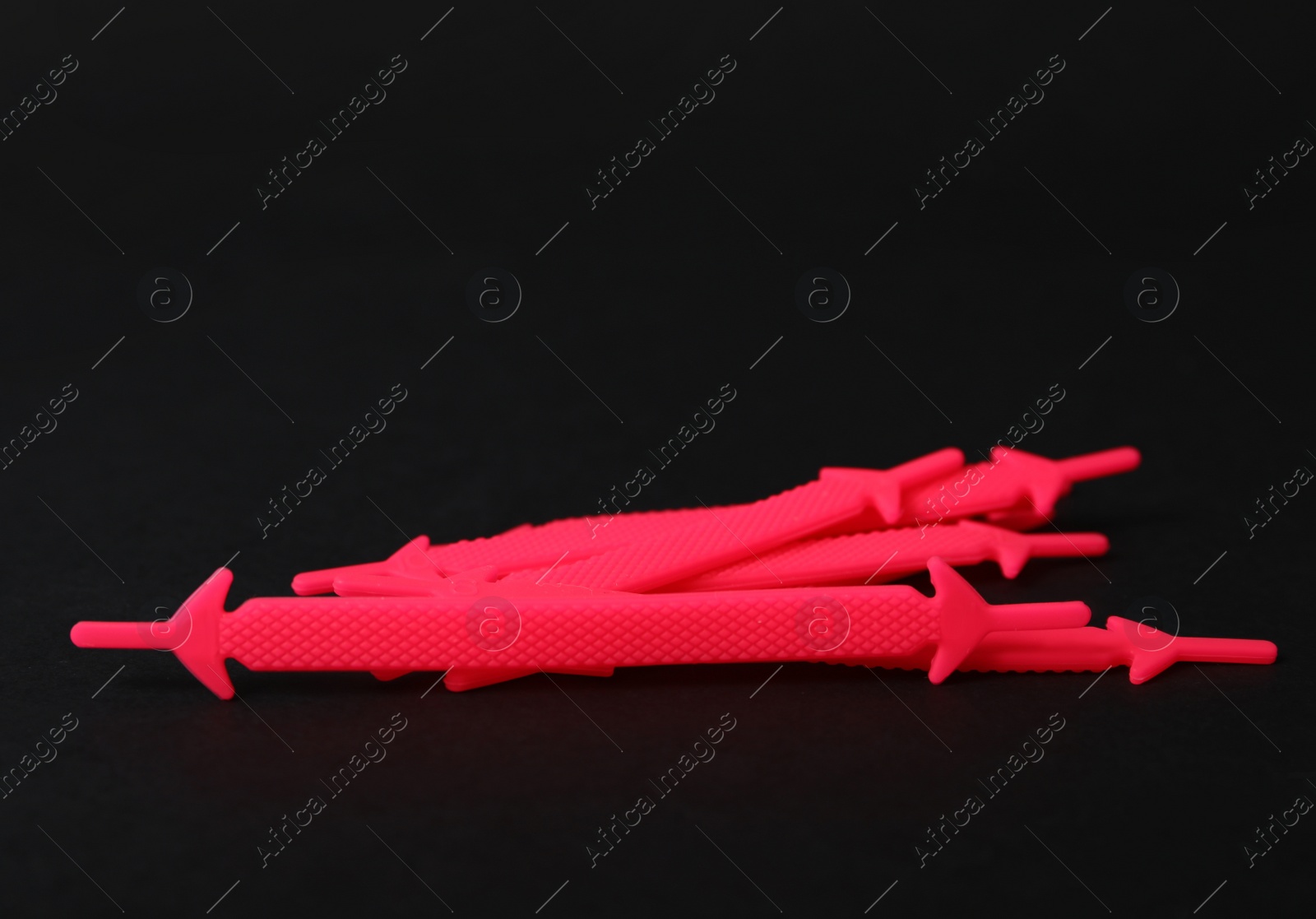 Photo of Pink silicone shoe laces on black background. Space for text