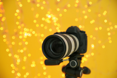 Photo of Modern professional video camera against blurred lights