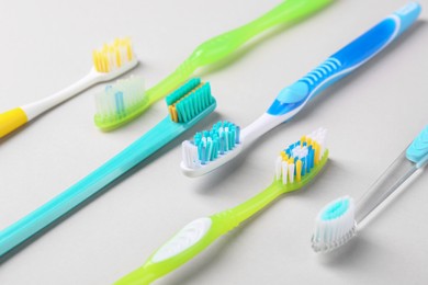 Many different toothbrushes on light background, closeup