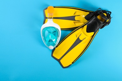 Photo of Swimming flippers and mask on color background, top view. Space for text