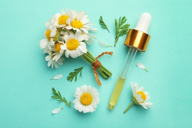 Photo of Flat lay composition with chamomile flowers and pipette of essential oil on color background