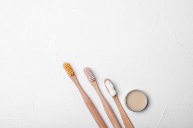 Flat lay composition with bamboo toothbrushes on white background