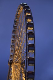 Photo of Beautiful large Ferris wheel against dark sky, low angle view