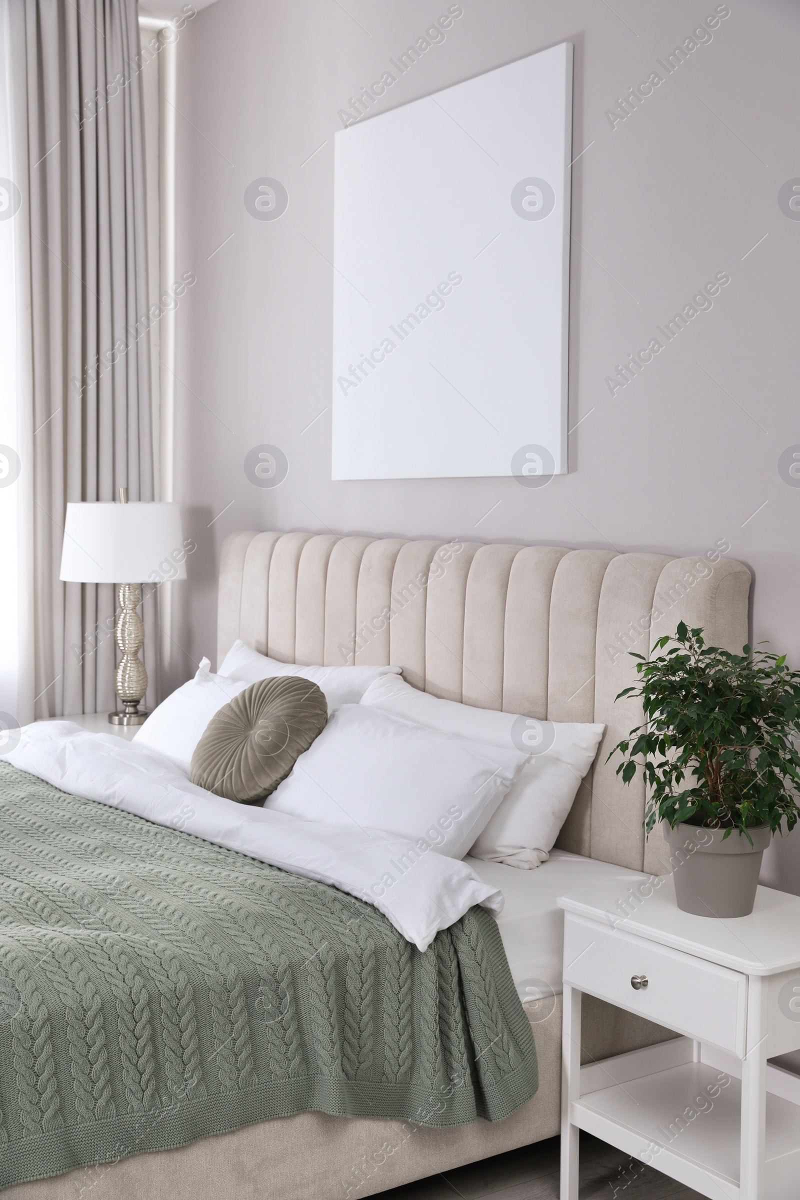 Photo of Blank canvas on wall in stylish bedroom interior. Space for design